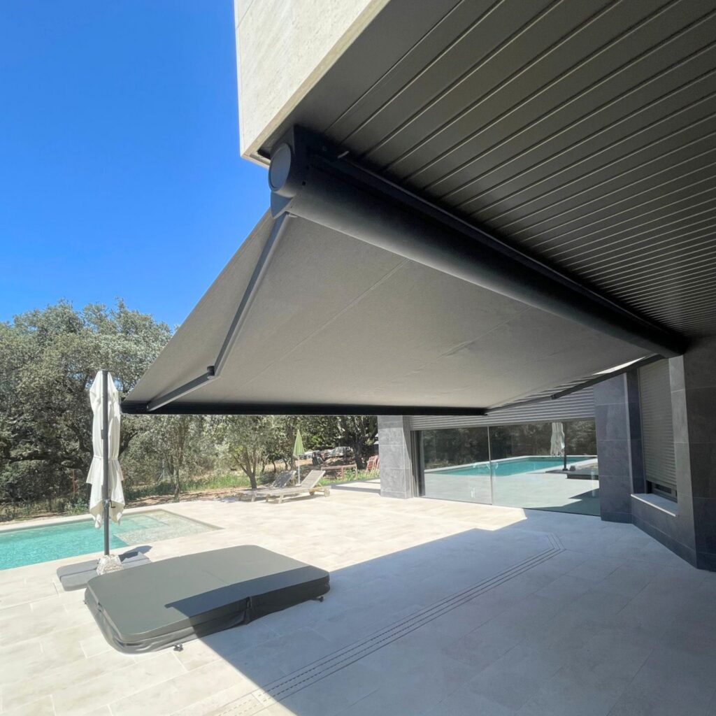 Toldo cofre gris instalado en una vivienda con piscina
